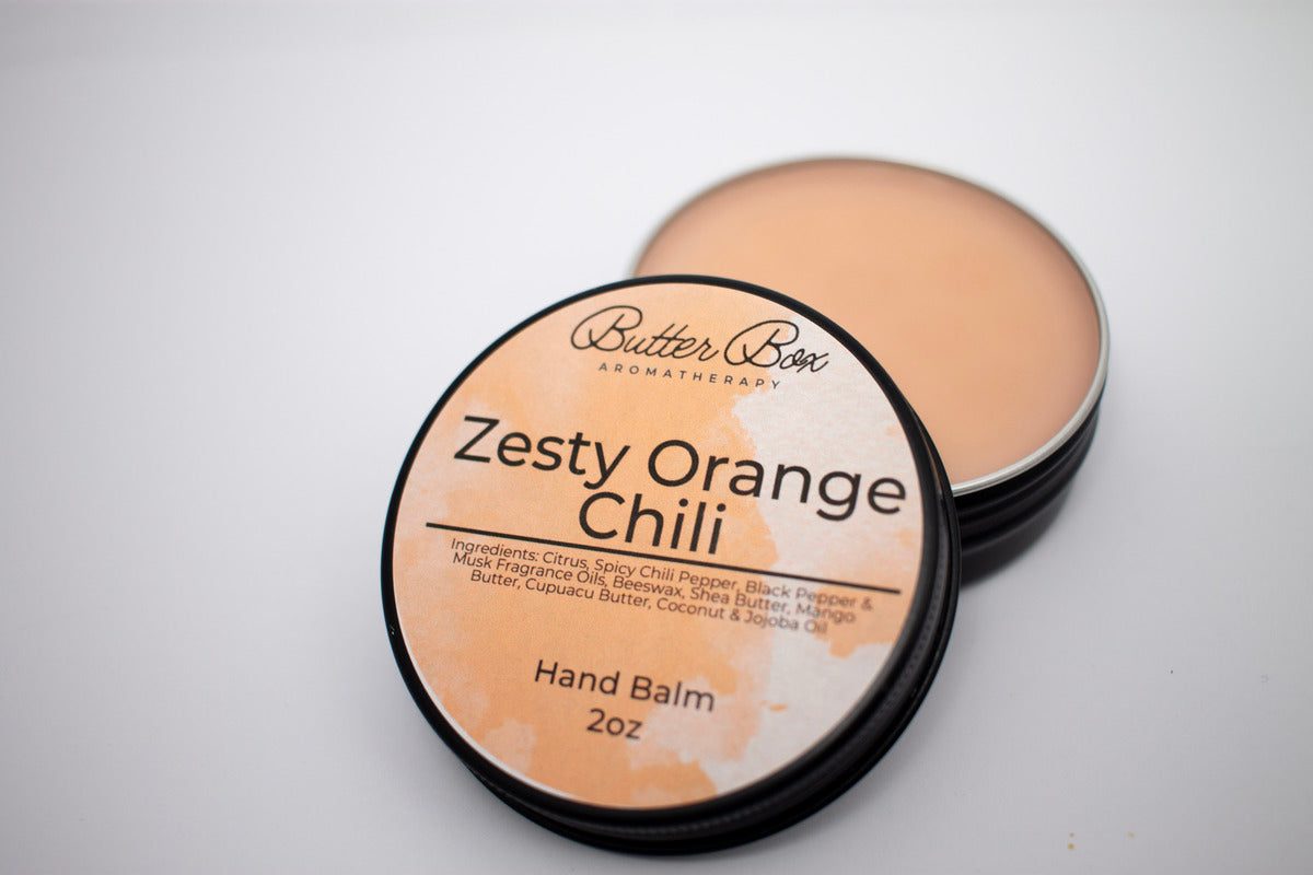 hand balm hand salve with an orange label in a black tin container